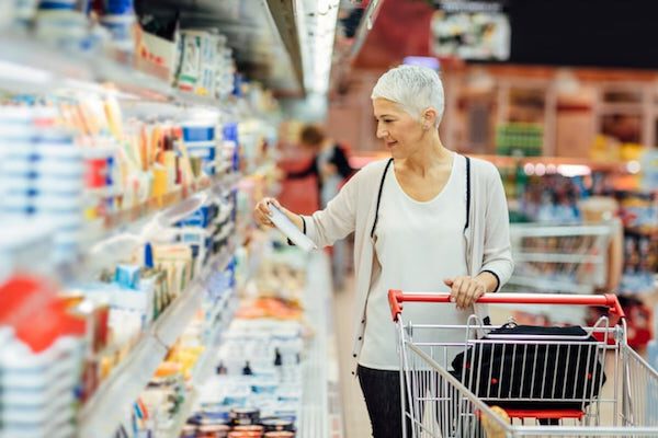 Frau beim Einkauf im Supermarkt mit Plastikverpackungen